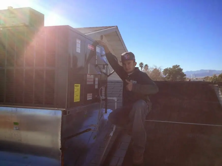 HVAC technician performing HVAC Inspection on a rooftop unit in Russellville